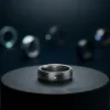 台座の上に置かれたチタン製スマートリングと、背景にぼやけて並ぶ複数のスマートリング（Galaxy Ring 販売終了と代替機のイメージ）